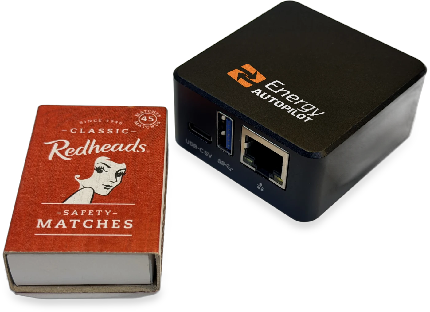 The Servo device beside a standard matchbox, with the Energy Autopilot logo on its top surface and its USB-C power, USB-A and RJ45 ethernet ports visible